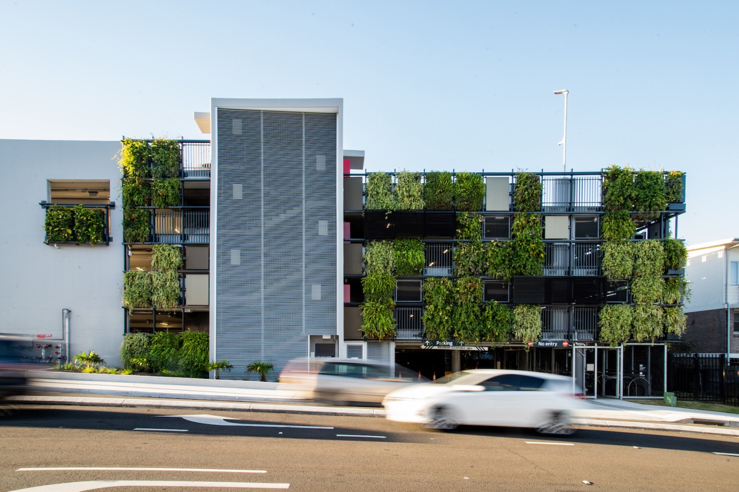 View down to Manly Vale B-Line Stop from upper level of Manly Vale carpark showing bicycle parking, stair and lift access.